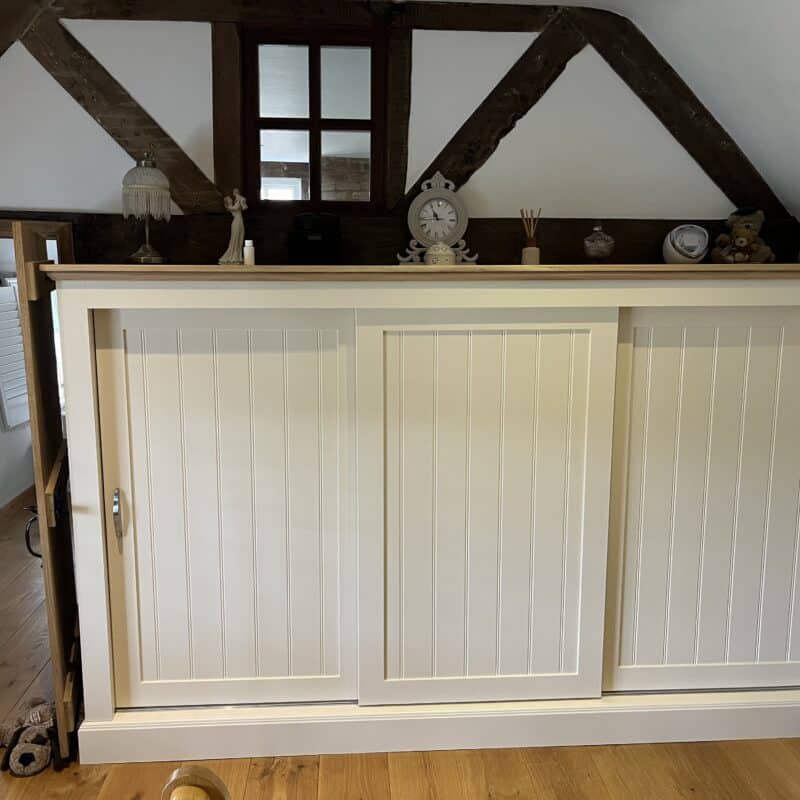 Custom-fit sliding door wardrobe – designed to maximise storage while fitting neatly into a sloped-ceiling alcove.
